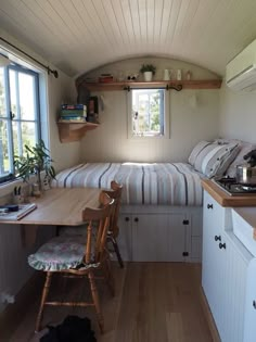 a small kitchen and dining area in a tiny home with wood flooring, white walls and ceiling