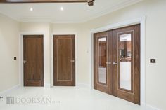 an empty room with three wooden doors in it