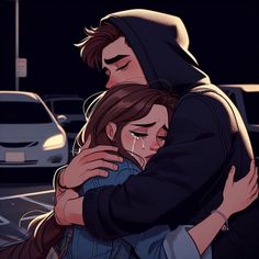 two people hugging each other in front of a parking lot at night with cars behind them