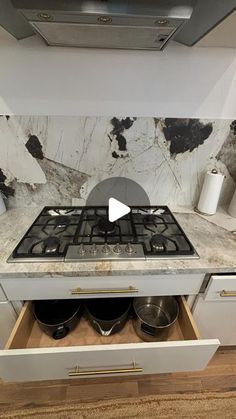 a stove top oven sitting inside of a kitchen next to a counter with pots and pans on it