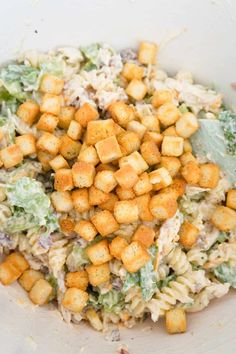 a bowl filled with salad and croutons on top of it