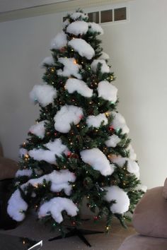 a small christmas tree is covered in snow