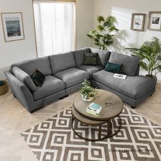 a living room with a sectional couch and coffee table on the floor in front of a window