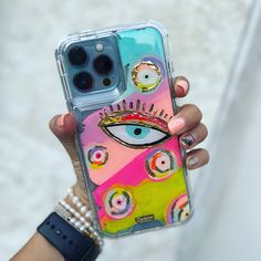 a person holding up a phone case with an eye painted on the front and sides