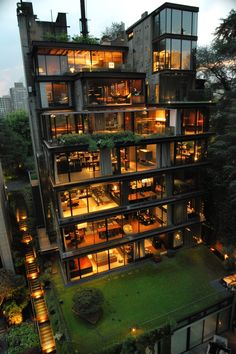 an aerial view of a building with many windows and plants growing on the top floor