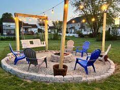 a fire pit with chairs and lights around it