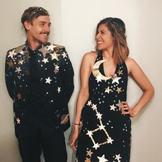 two people standing next to each other in front of a wall with stars on it