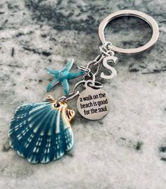 a keychain with a starfish and seashell on it that says, a walk on the beach is good for the soul