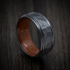 a wooden ring with black and grey camo inlays on the inside is sitting on a table