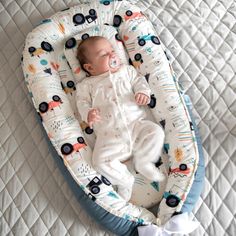 a baby laying in a bed with wheels on it