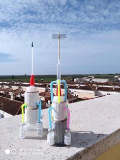 two plastic cups with toothbrushes in them on top of a building