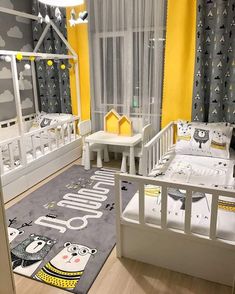 a child's bedroom with yellow walls and grey carpeted flooring, white cribs and black curtains