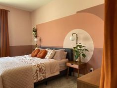 a bed room with a neatly made bed next to a window and a potted plant