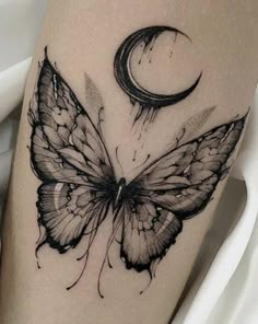 a black and white butterfly with a crescent tattoo on the thigh