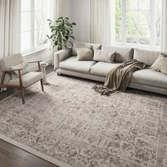 a living room with a couch, chair and large rug in front of two windows