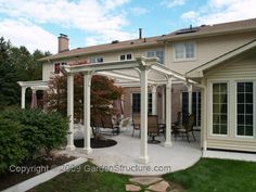 an outdoor patio with white pillars and chairs