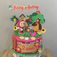 there is a cake that has been decorated with animals and flowers on the top layer