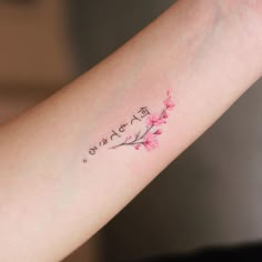 a woman's arm with a small tattoo on it