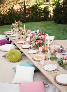 a long table with plates and candles on it