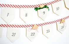 a red and white striped ribbon is hanging on a wall next to numbered pennants