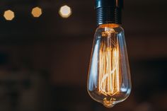 a light bulb hanging from a ceiling with lights in the background