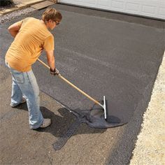 a man is using a shovel to clean the asphalt