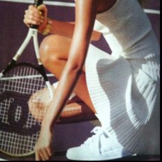 a woman holding a tennis racquet on top of a tennis court