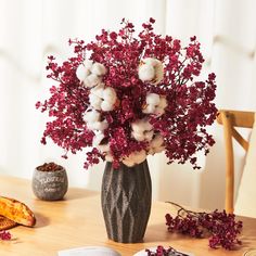 a vase filled with flowers sitting on top of a table next to an open book