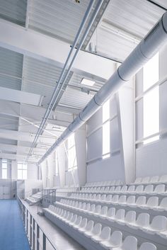 an empty stadium with white seats and blue carpet