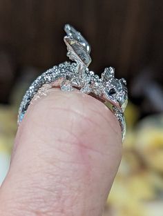 Introducing our adorable adjustable baby dragon fashion ring, the perfect accessory for any occasion! Crafted with attention to detail, this elegant piece features an intricate design that wraps around your finger, adding a touch of sophistication to your look. Treat yourself or surprise a loved one with this timeless accessory that is sure to add a unique twist to your everyday style. Order yours today and elevate your jewelry collection to new heights! This handcrafted ring is sealed to preven Silver Whimsical Jewelry For Promise Ring, Whimsical Silver Promise Ring Jewelry, Unique Adjustable Dragon Design Jewelry, Adjustable Unique Jewelry With Dragon Design, Dragon Design Ring Jewelry Gift, Dragon Design Ring Jewelry For Gift, Elegant Adjustable Dragon Design Jewelry, Adjustable Dragon Design Ring, Elegant Adjustable Jewelry With Dragon Design