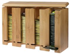 a wooden shelf with several compartments and gold foiled items in it, on white background