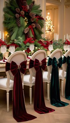 the table is set for christmas dinner with red and green bows on it's chairs