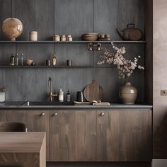 a kitchen with wooden cabinets and shelves filled with pots, pans and vases