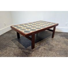 a coffee table sitting on top of a carpeted floor next to a white wall