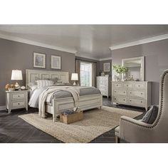 a bedroom with gray walls and white furniture