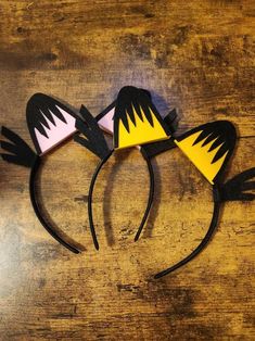 three ears are made to look like they have yellow, pink and black shapes on them