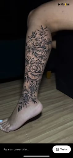 a woman's foot with flowers and leaves on the bottom part of her leg