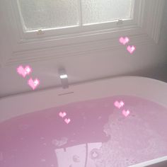 a bathtub with pink hearts floating in it