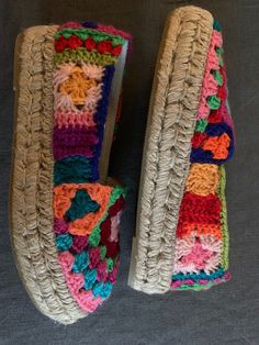 two crocheted slippers are sitting next to each other on a gray surface