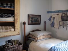 a bed room with two beds and a shelf filled with clothes on the wall next to it