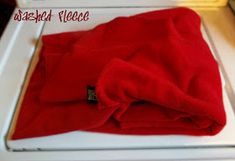 a red blanket sitting on top of a white stove