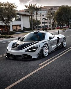 a white and black sports car driving down the street