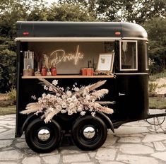 an old - fashioned food truck is decorated with flowers and candles on the front wheel