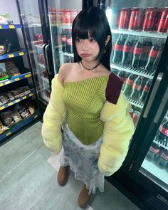 a woman standing in front of a refrigerator filled with drinks