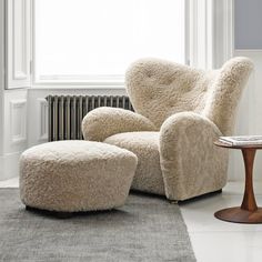 a chair and ottoman in front of a window with a rug on the floor next to it