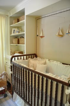 a baby's crib in the corner of a room with bookshelves