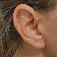 a close up of a person's ear with small diamond studs on it