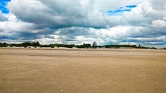 there are clouds in the sky over an empty field with no grass or people on it