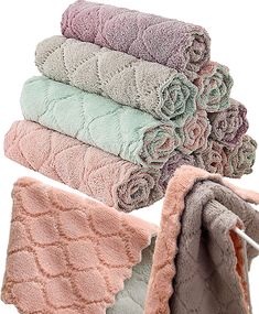 four towels stacked on top of each other in different colors and patterns, with one folded up