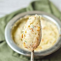 a spoon with some food on it in a bowl